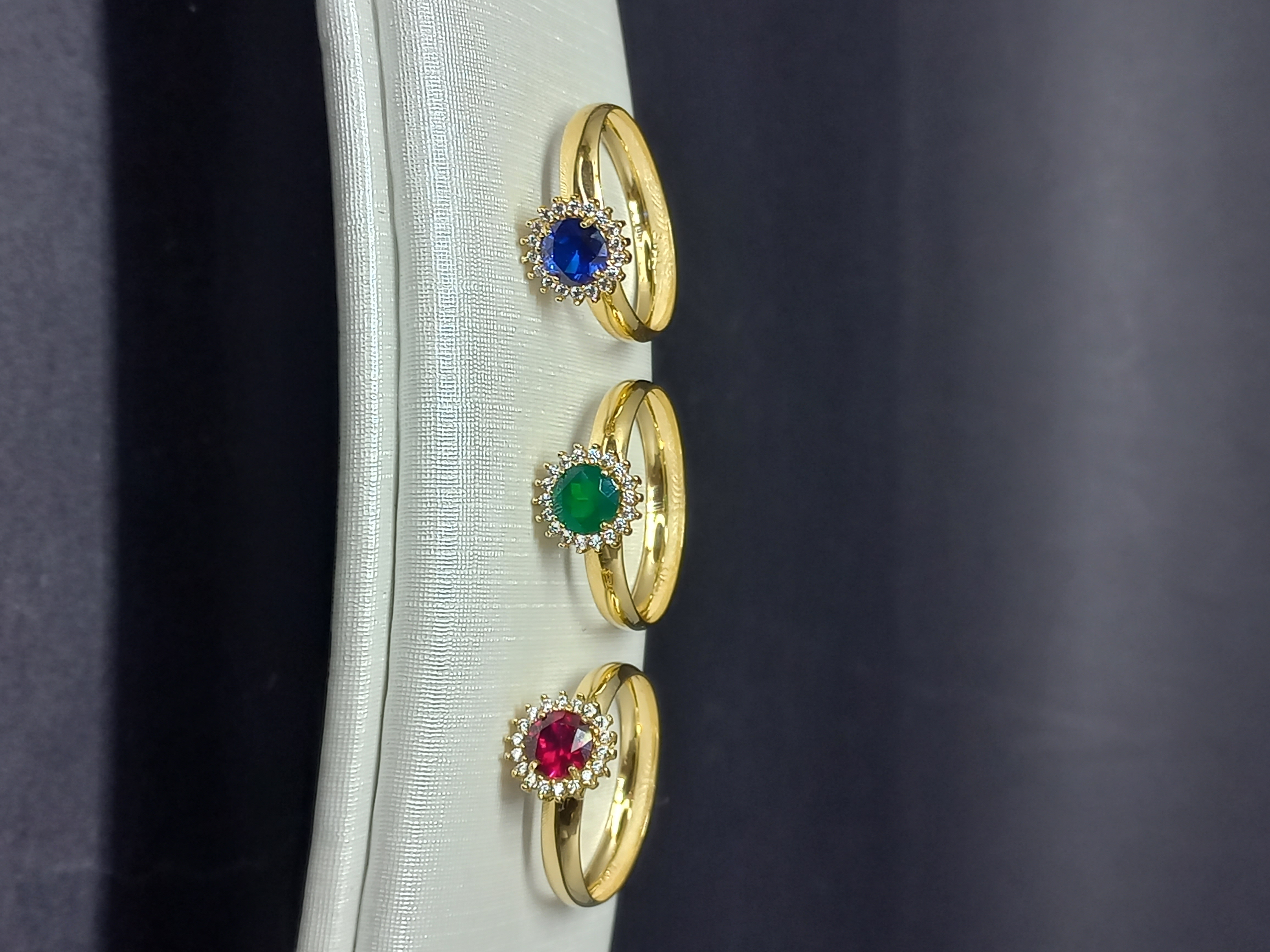 Trio de anéis halo — safira, esmeralda e rubi